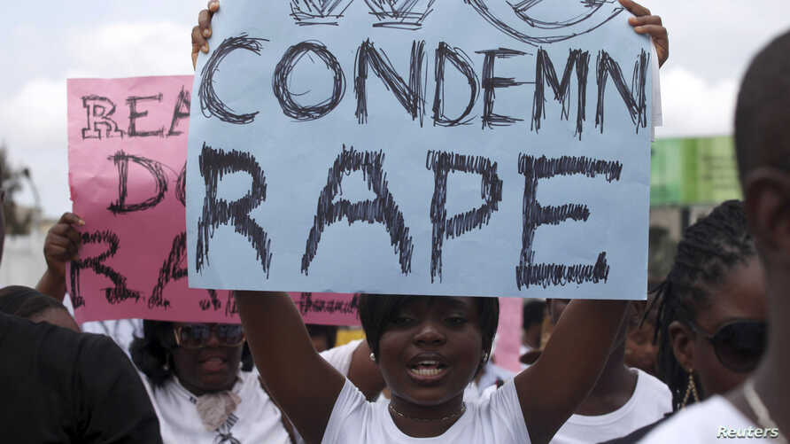 A woman carries a placard as she shouts a slogan during the “walk against rape'” procession organised by “Project Alert”, a Lagos-based NGO focusing on women’s issues, in Lagos